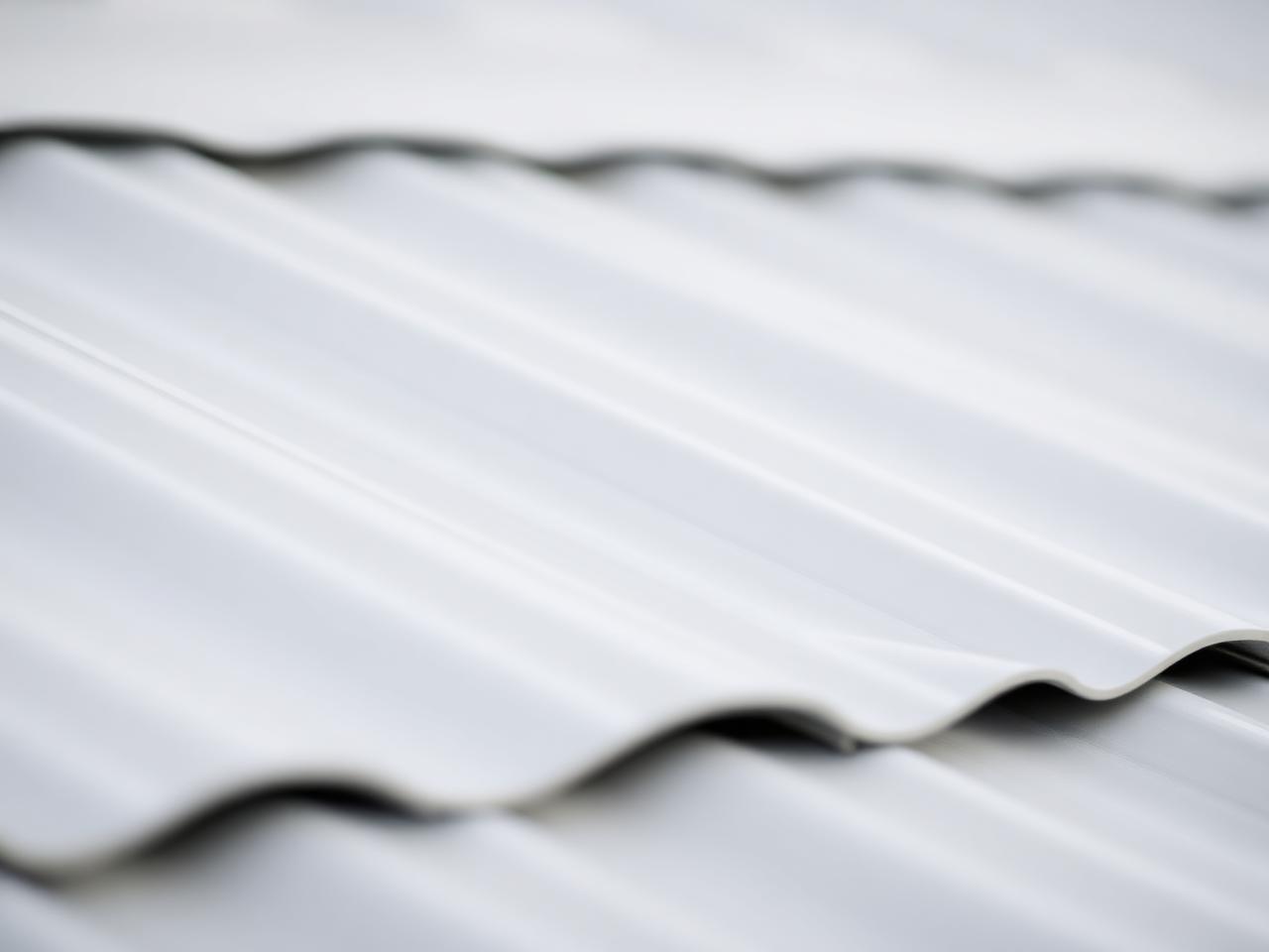 Macro detail of reflective cooling coating on a metal roof panel